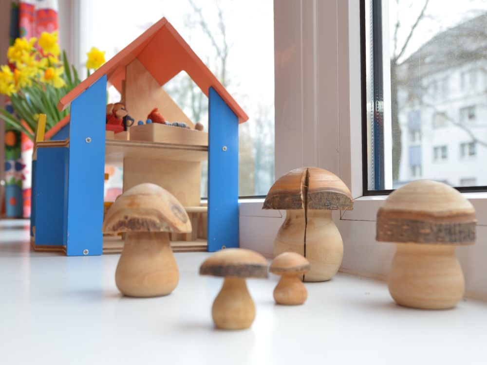 Fensterbank mit gelben Blumen, Puppenhaus und Spielzeug